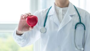 geriatric physician holding a heart shape